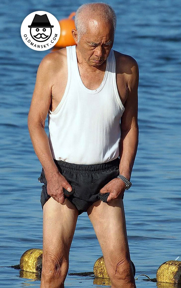 Old man wore a white vest undershirt and a black middle pants at the sea_04