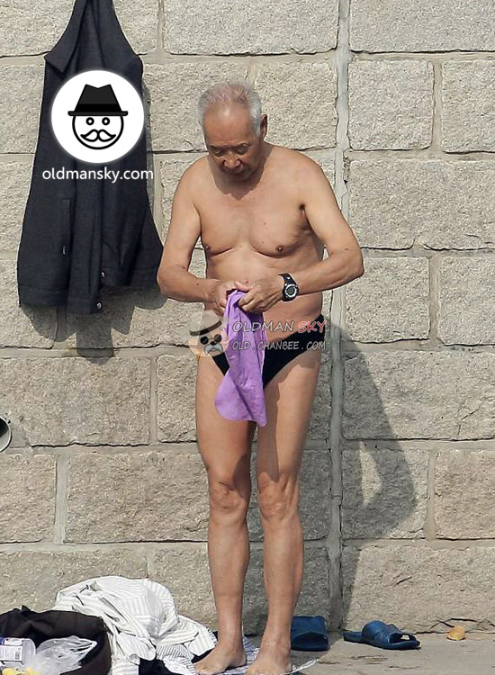 Thin swimming old man wore a black underwear stood by the river_05