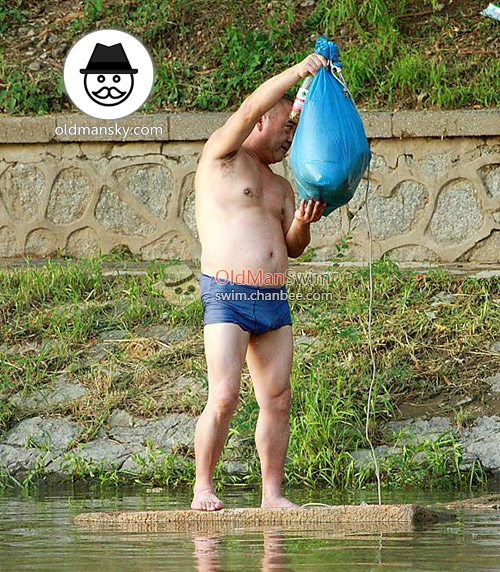 Swimming daddy wore a blue boxer underwear stood by the river