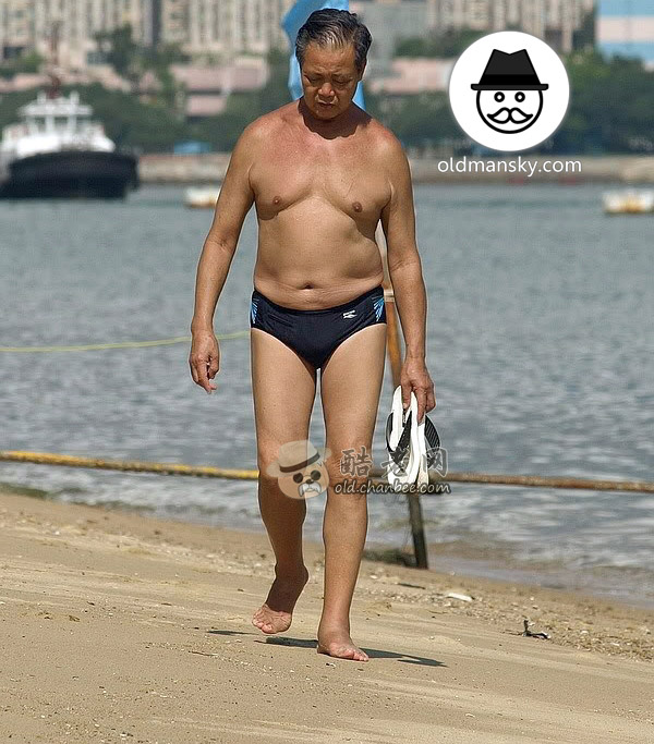 Swimming old man wore a black underwear walked on the beach