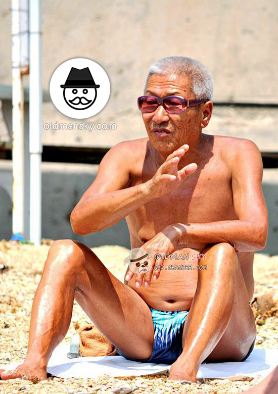 White hair swimming old man wore a sunglasses sat on the beach