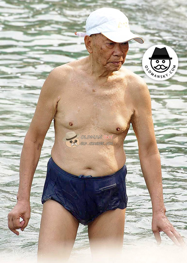 Swimming old man wore a white cap and brown underwear got out of river