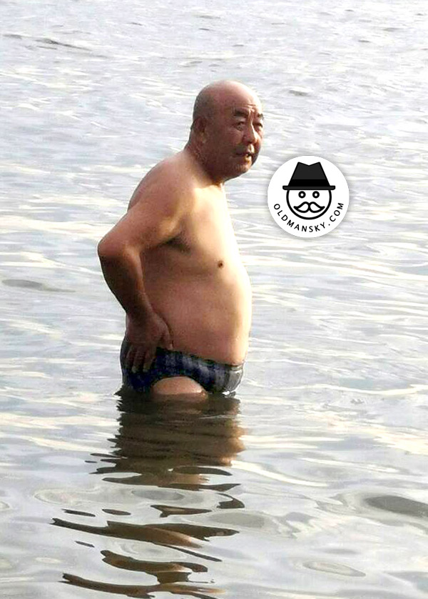 Swimming fat old daddy wore a strip underwear stood at the sea